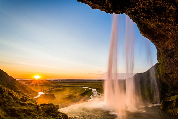Самый известный и живописный водопад Исландии — один из немногих, которые можно наблюдать «изнутри»: из скального грота за мощными потоками воды